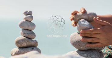 Sassi impilati in equilibrio e mani che costruiscono un'altra pila di fianco a simboleggiare l'equilibrio mentale