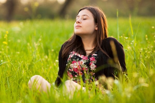 Ragazza in pace nel prato ha trovato il suo equilibrio mentale